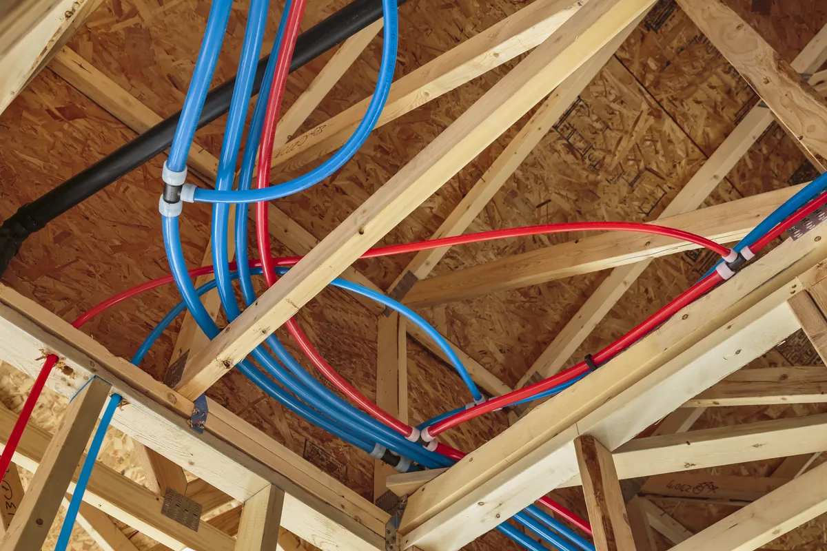 Red and blue PEX water lines run through attic trusses – Planning a Rinnai Tankless Water Heater Installation for Your Ladera Ranch Home for Ladera Ranch, CA homes