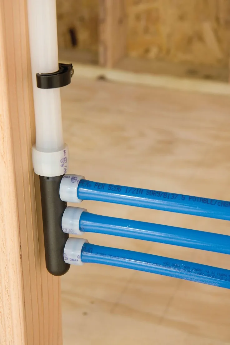 Blue PEX lines leaving a manifold fastened to a wall stud – Navien Tankless Water Heater Installation for Ladera Ranch, CA homes